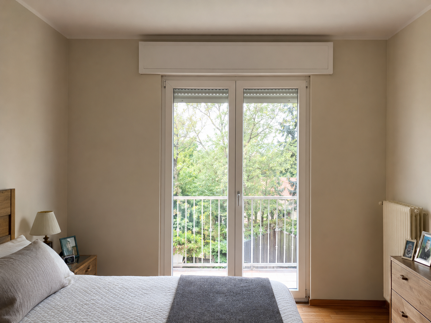Cassonetto in PVC bianco sopra una portafinestra in una camera da letto
